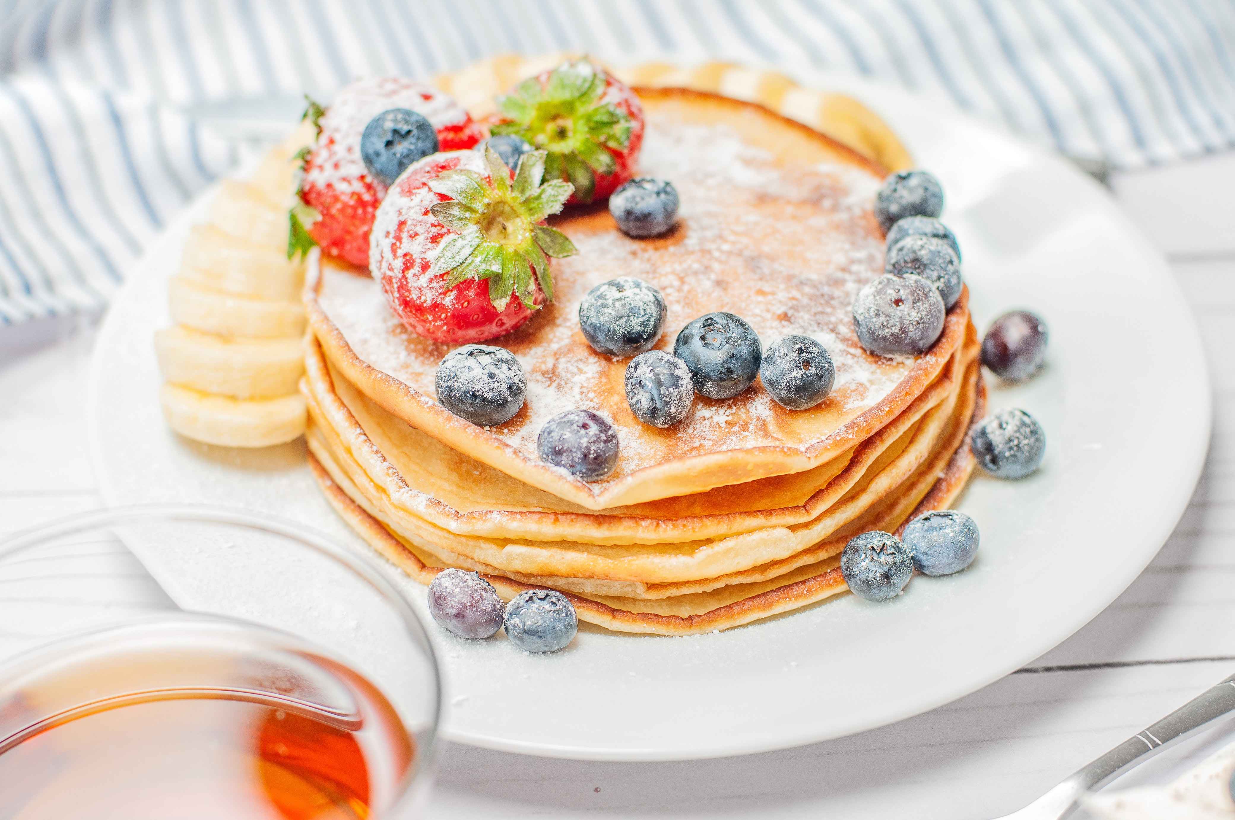 A plate of fresh pancakes, strawberrys and blueberrys