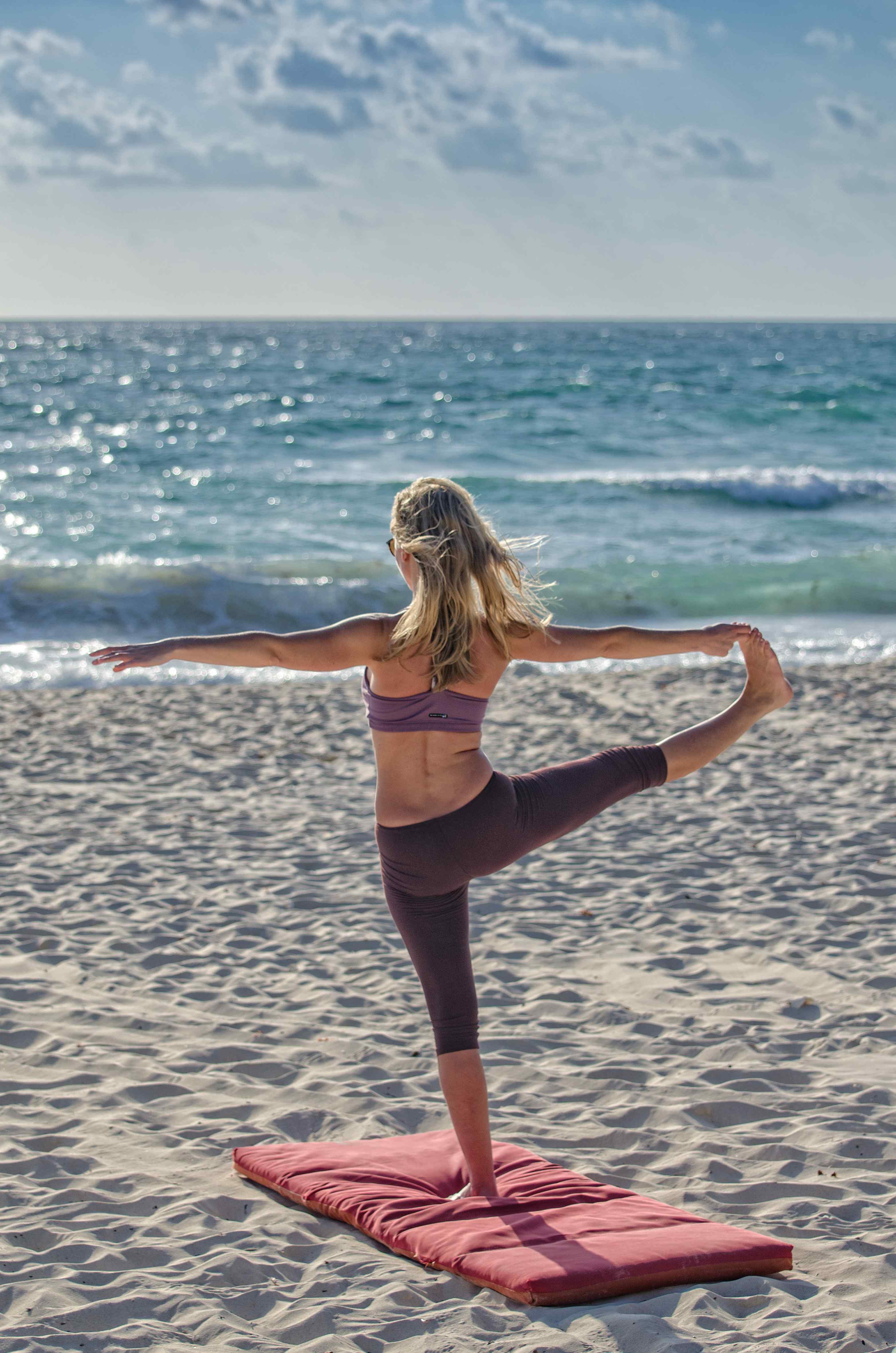 Girl in yoga position on the beach